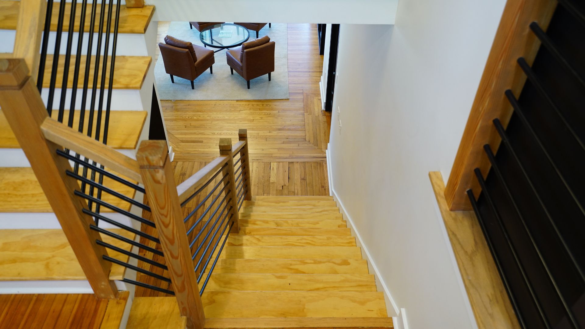 Staircase aerial view looking down to leather-chair lobby at 521 N McDuffie Workspace