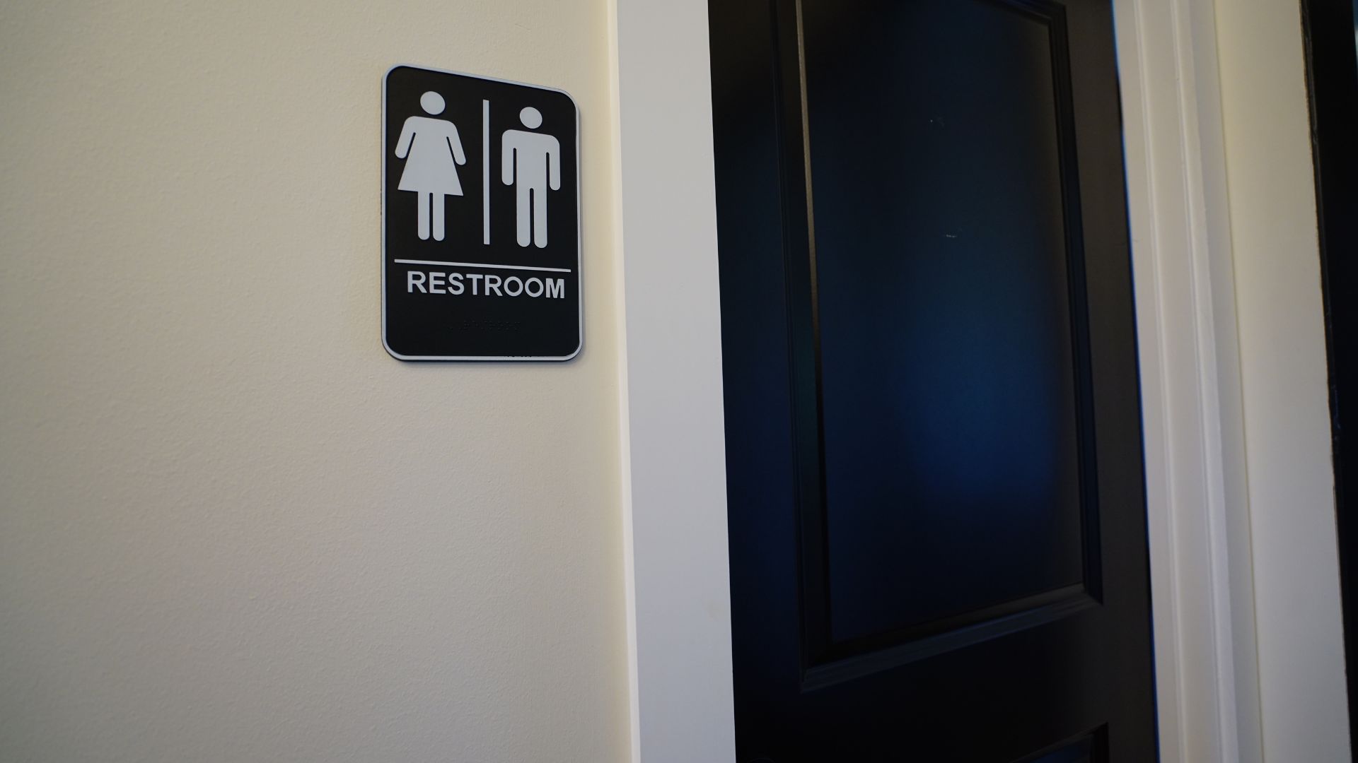 Restroom with ADA-compliant signage, available to all tenants at 521 N McDuffie Workspace