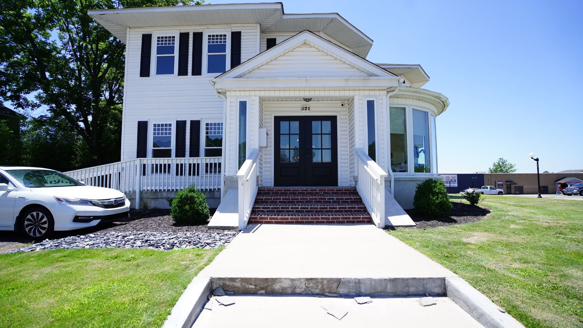 Front entrance of 521 N McDuffie Workspace with brick steps and double black doors, Anderson SC